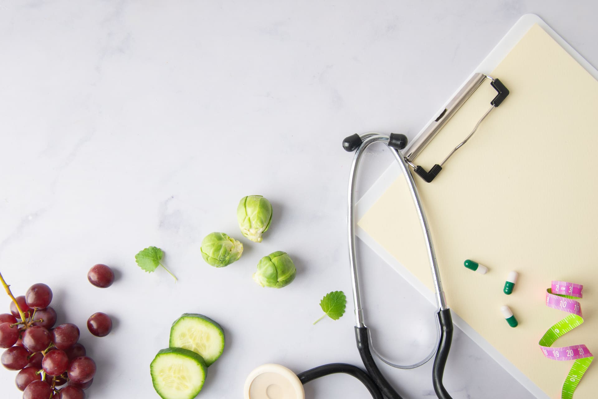 top-view-stethoscope-with-cucumber-slices-grapes